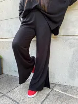 Pantalón de lanilla gris con lurex, corte palazzo y abertura en el lateral inferior.