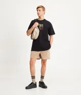 Bermuda masculina tipo runner color beige, confeccionada en terciopelo acanalado, con cintura elástica, cordón de ajuste y bolsillos laterales.
