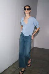 Jersey celeste de punto liso, con cuello redondo, manga larga y botones delanteros.