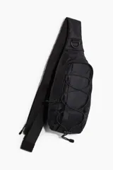 Bolso cruzado de deporte negro en tejido grueso. Tiene un compartimento grande con cierre y cordón elástico entrelazado adelante con tope de plástico. La correa es ajustable y levemente acolchada, con un compartimento de cierre atrás, argolla en D adelante y hebilla de plástico.