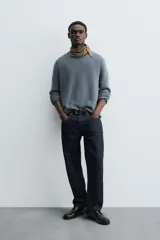 Sweater azul de punto con textura, corte holgado, cuello redondo y mangas largas con puños acanalados.