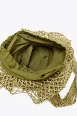 Bolso shopper de hombro color verde oliva, trenzado con cordones gruesos. Tiene doble asa ancha para el hombro y un bolso interior de tela con cierre fruncido.