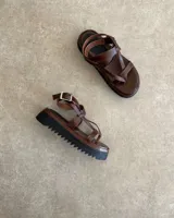 Sandalias de cuero vacuno color negro, con tiras finas y suela plana.