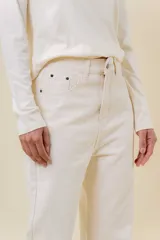 Jean de corte recto y tiro medio en color crudo. Cuenta con diseño clásico de cinco bolsillos, cierre frontal con botón y cremallera, y pasacintos.