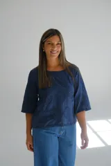 Blusa azul marino con bordado calado, escote cuadrado y mangas 3/4 acampanadas.