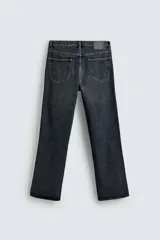 Pantalón de jean de tiro medio, color gris oscuro con efecto lavado, corte ajustado en la parte superior y acampanado desde la rodilla, con cinco bolsillos y cierre frontal con cremallera y botón.