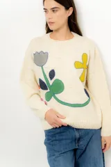 Sweater de lana color crema con cuello redondo y diseño de flores bordadas en colores gris, amarillo, verde y azul.