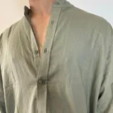 Camisa de lino color blanco, de manga larga con puños abotonados y cuello mao. Corte oversize.