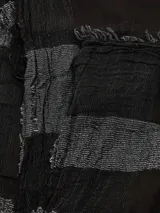 Bufanda rectangular con flecos en los extremos, con diseño a rayas horizontales en tonos negro y gris.