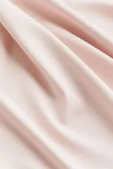 Remera entallada rosa pálido de punto suave con cuello redondo fino ribeteado y mangas cortas.
