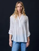 Blusa blanca de gasa bambula, marca Zac & Rachel. Cuello a la base, escote en V con apertura y botones. Largo de manga regulable con presilla y botón.