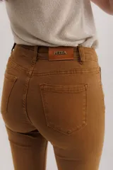 Pantalón jean marrón acampanado con detalle desflecado en el bajo y tiro medio.