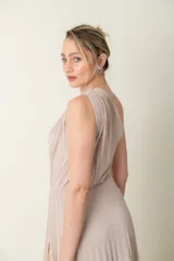 Vestido largo de lurex plisado color dorado, con un solo hombro, falda con abertura lateral y short incorporado.