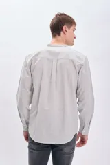 Camisa de manga larga con cuello mao y cierre frontal con botones. Diseño a rayas verticales en tonos blanco y marrón.