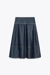 Falda midi de tiro alto confeccionada en denim azul oscuro. Presenta costuras a contraste y cierre lateral con cremallera metálica.