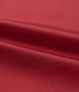 Musculosa color rojo oscuro, confeccionada en satén, con escote drapeado (degagê) y breteles ajustables. El bajo de la prenda es asimétrico.