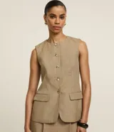 Short pollera de poliéster color beige, de corte sastrero, con cintura alta, pliegues delanteros y cintura lisa.