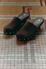 Zueco marrón de serraje con tacón kitten y detalle de tachas doradas en la base.