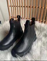 Botas de cuero negro con elástico a los lados, suela de cuero y forro de cuero vacuno.