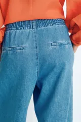 Pantalón culotte de denim azul claro, con cintura elástica fruncida, bolsillos laterales y corte holgado.