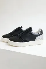 Championes urbanos de cuero color negro con cordones negros y suela blanca. Incluye un par de cordones adicionales de otro color.