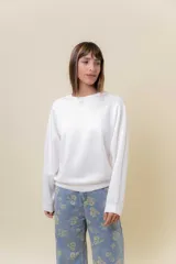 Buzo de manga larga color blanco, con cuello redondo y calce relajado.