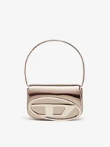 Bolso bandolera Diesel modelo 1DR, color violeta metalizado, con asa corta rígida y correa larga extraíble. Presenta solapa con cierre magnético y logo ovalado "D" en relieve.