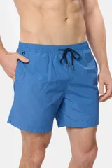 Short de baño azul vibrante, de corte clásico y largo medio, con cintura elástica y cordón ajustable. Cuenta con bolsillos laterales y suspensor de malla fina interior.