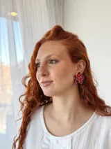 Aros colgantes con forma de flor roja con borde plateado y centro de cuentas rojas facetadas.