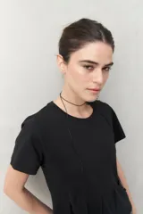 Remera blanca de manga corta con cuello redondo y costuras verticales en el frente.