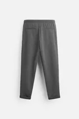 Pantalón negro de corte cropped, con cintura elástica ajustable con cordón, bolsillos laterales y traseros de vivo. El bajo tiene terminación con vuelta.