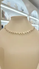 Collar corto de nácar con forma de flores blancas y detalles dorados en acero.