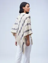 Poncho con tejido combinado en tonos beige y gris, decorado con flecos.