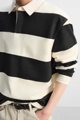 Sudadera tipo polo con cuello clásico, manga larga y diseño a rayas horizontales en color verde oscuro y crudo.