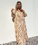 Vestido largo tipo túnica con estampado de cebra en tonos beige y crudo, con cuello en V y mangas 3/4.