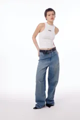 Jean oversized de tiro bajo, color azul lavado, con estampa BLKMBA grabada con láser en el frente y estampa worldwide en la parte trasera.
