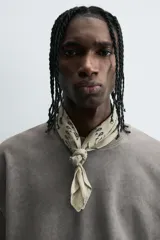 Camiseta color beige de corte holgado, cuello redondo y manga corta.