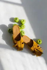 Zuecos negros con diseño de tiras entretejidas y suela plana color madera.