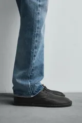 Zapato de cordones tipo derby, color negro, con capellada de cuero abatanado, plantilla de cuero y suela ultrafina.