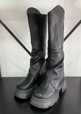 Botas bucaneras negras de cuero vegano, con polainas integradas y suela track.