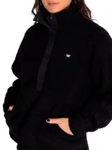 Buzo polar gris de mujer con cuello alto abotonado y bolsillo tipo canguro. Tiene un parche redondo con el logo de Cat en el lado izquierdo del pecho y broches con el logo de Cat en la parte delantera.