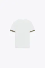 Camiseta blanca de corte slim fit, cuello redondo y manga corta. Detalle de acabados en tricot con hilo metalizado color dorado en mangas y bolsillo.
