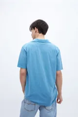 Chomba color ocre, de algodón lavado, con cuello clásico y bordado en el pecho.