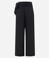 Pantalón pantalona de sastrería color negro, confeccionado en tejido texturizado. Presenta corte amplio, superposición lateral con lazo y tiro alto.