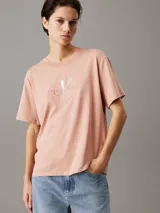 Remera color salmón de corte holgado con cuello redondo y mangas cortas. Presenta el logo de Calvin Klein Jeans bordado en el pecho.