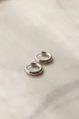 Par de aros tipo argolla gruesos de acero quirúrgico hipoalergénico color plateado.