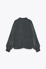 Camisa gris confeccionada en seda 100%, de cuello redondo y manga larga abullonada con puño. Cierre frontal con botones ocultos por solapa.