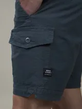 Bermuda de gabardina color ocre, con bolsillos laterales tipo cargo y corte a la rodilla.