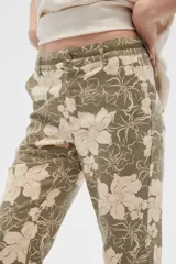 Pantalón de lino color verde oliva con estampado de flores color crema, de corte recto.