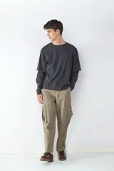 Pantalón cargo color caqui, de corte recto, con múltiples bolsillos delanteros, laterales y traseros.